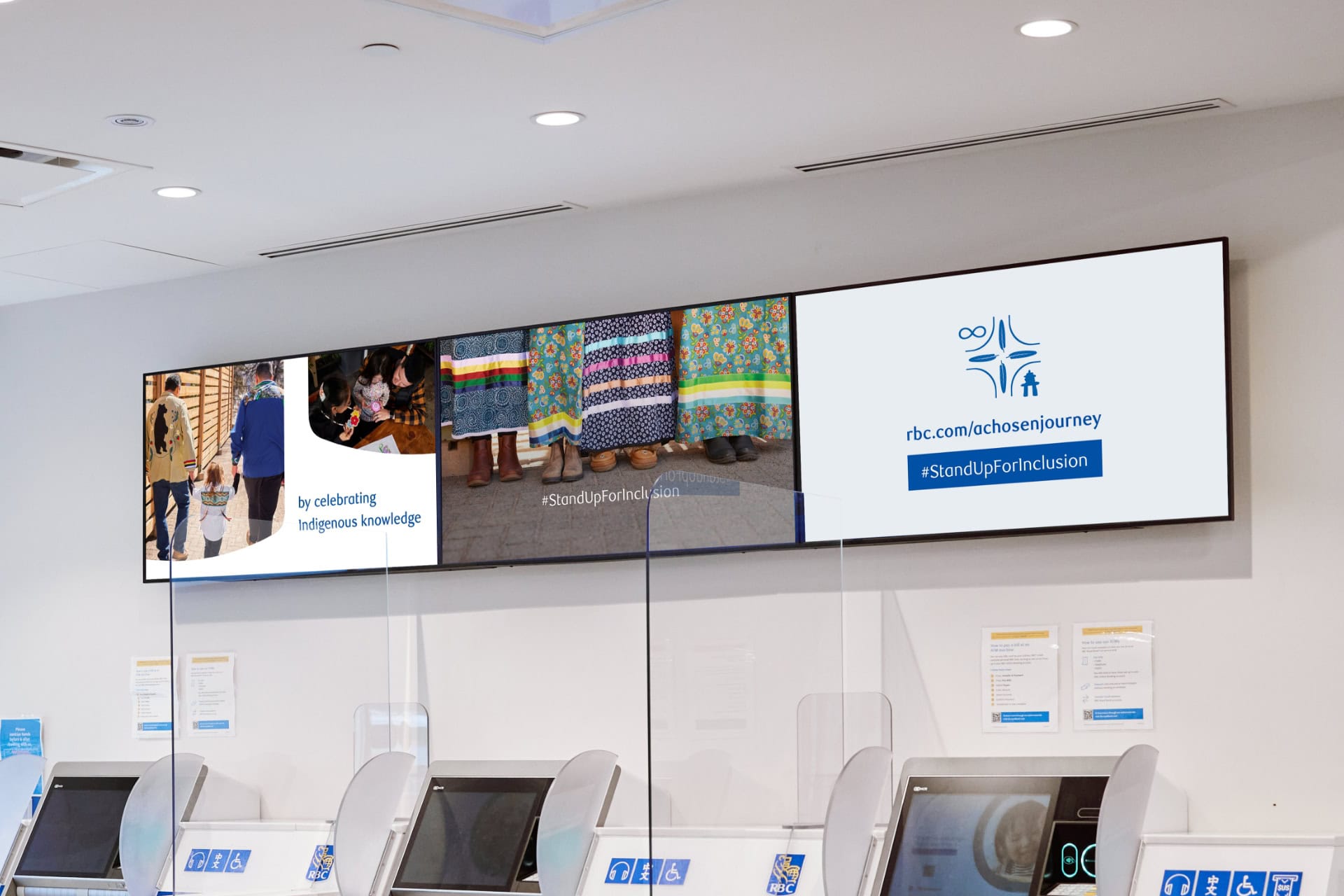 An interior view of an RBC branch. There are screens display A Chosen Journey messaging and imagery above teller machines.