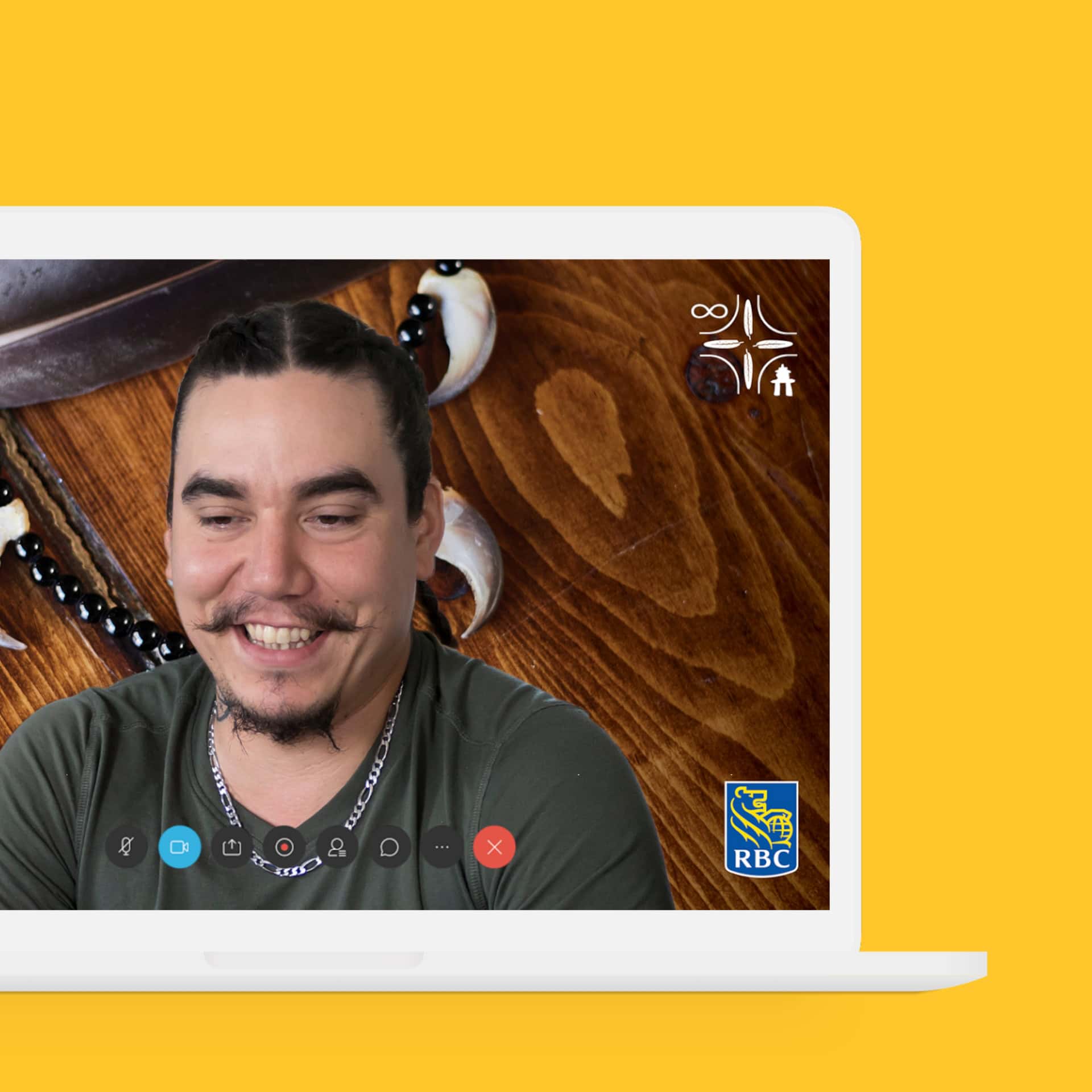 A laptop faces the viewer against a yellow background. The laptop screen shows an Indigenous man smiling during a video call, with the RBC logos against the background on the laptop screen.