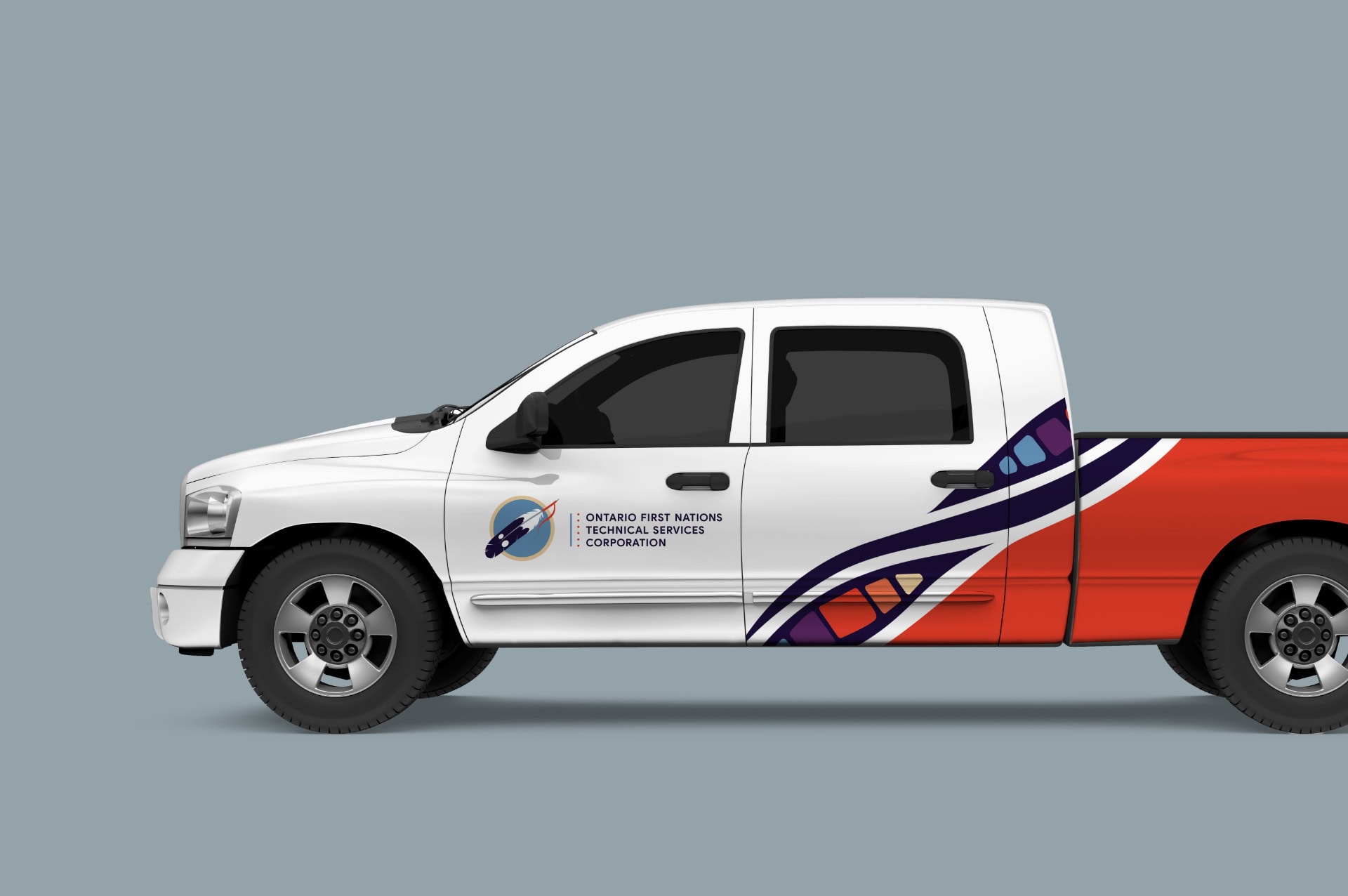 A mockup of a company truck for OFNTSC. Pictured is the drivers side view of the truck. The truck features the OFNTSC logo on the door, on a white background. The back of the truck is orange, in a diagonal reaching to the bottom of the back door. Separating the two sections is one curved line, and two pointed ovals featuring colour blocks of yellow, orange, red, and deep purple in one, and deep purple and blue in the other, separated into sections by black lines.