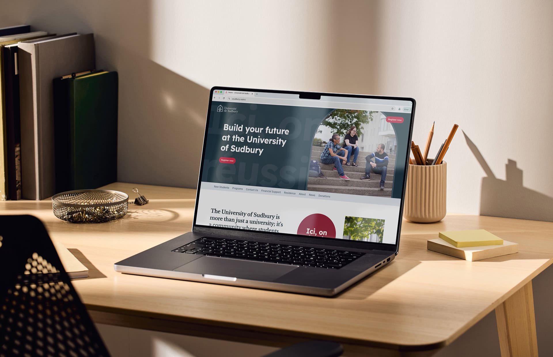 Laptop resting on a clean desk displaying the Université de Sudbury website