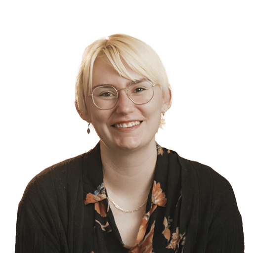 A white person with short blonde hair and brown eyes wearing glasses.