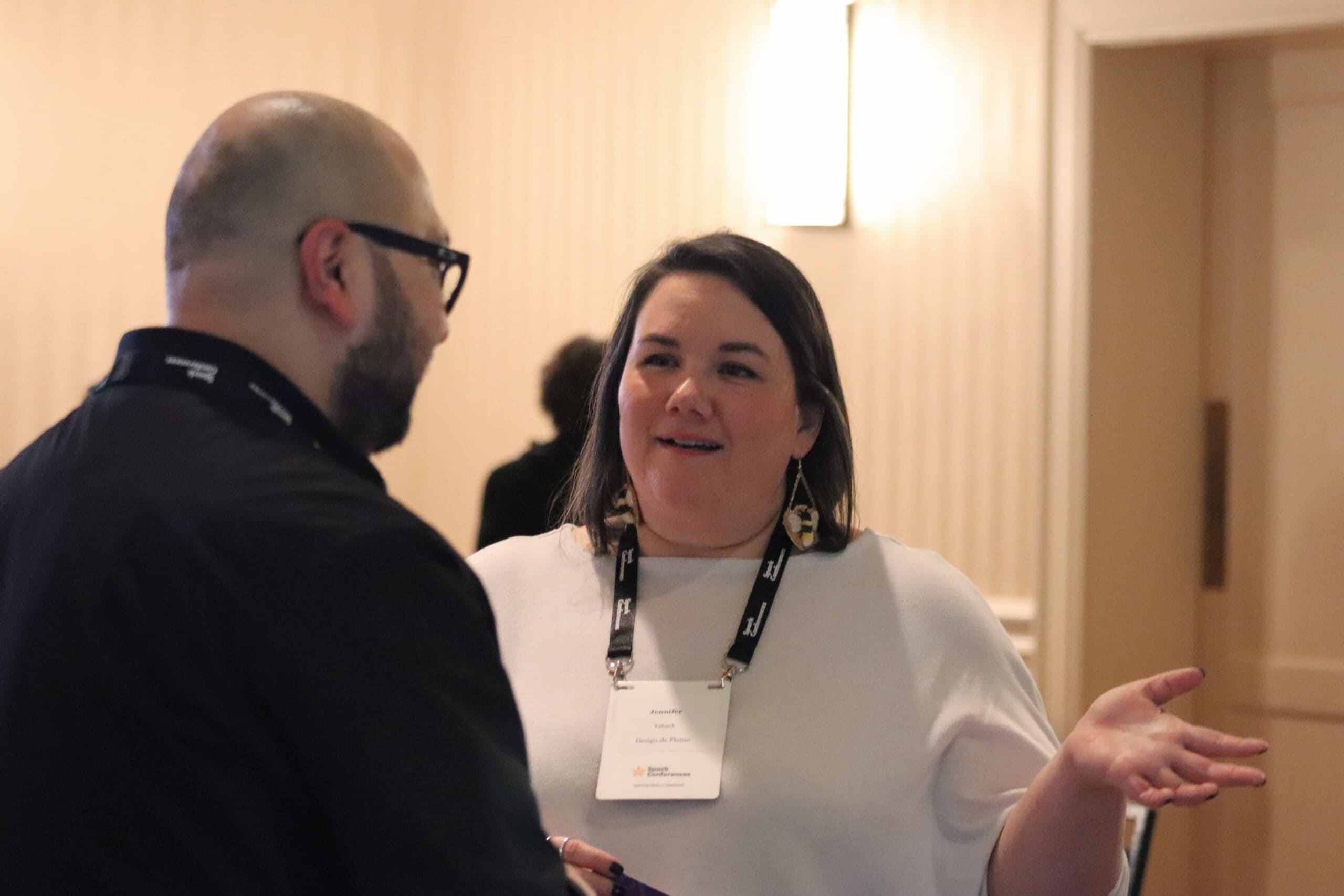 JenniferTabackSpeaking Jennifer Taback gesturing as she speaks with a conference attendee after her talk.